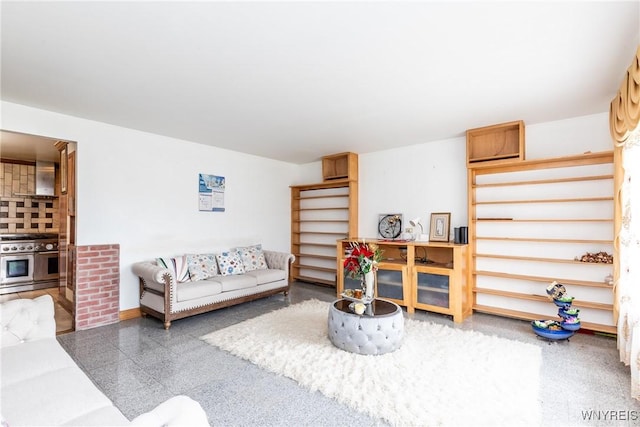 living room featuring baseboards and granite finish floor