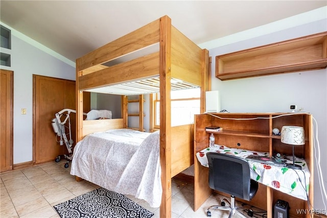 bedroom featuring light tile patterned floors and lofted ceiling