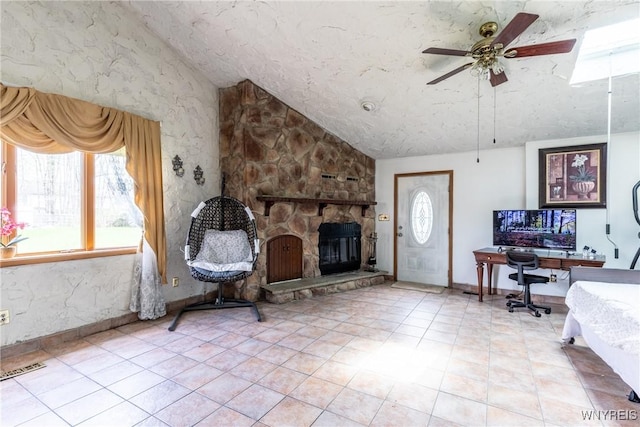 living room with ceiling fan, visible vents, a stone fireplace, and lofted ceiling