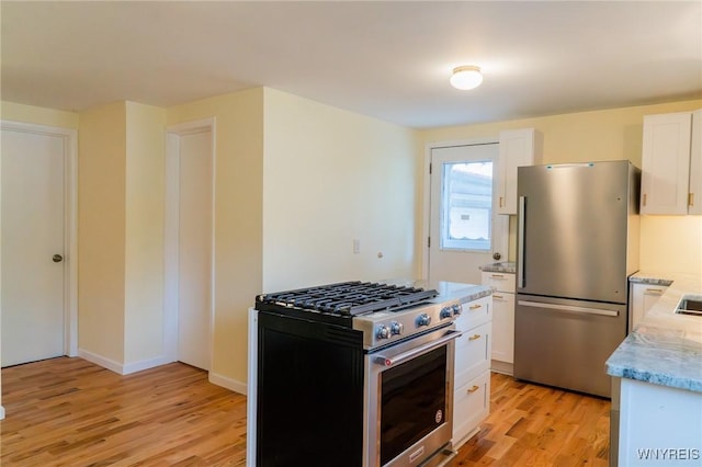 38 Carol Ave, Pomfret, NY 14063 - kitchen with appliances with stainless steel finishes, light wood-type flooring, white cabinetry, and light stone counters