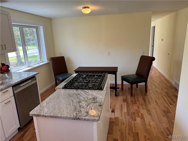 38 Carol Ave, Pomfret, NY 14063 - kitchen with dishwasher, light wood finished floors, a kitchen island, light stone countertops, and white cabinetry