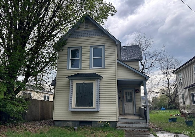 view of front of property with fence and a shingled roof