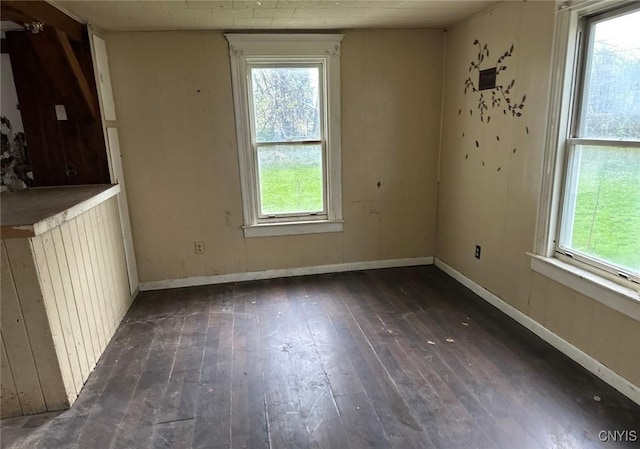 unfurnished dining area with a healthy amount of sunlight, baseboards, and hardwood / wood-style floors