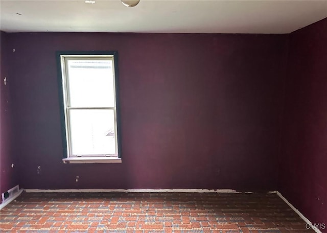 unfurnished room with baseboards