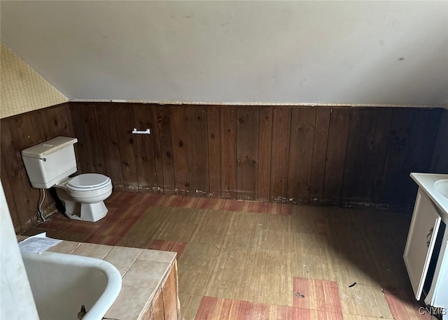 full bath featuring toilet, wallpapered walls, a bath, tile patterned floors, and a sink
