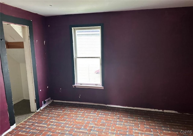 spare room with baseboards and plenty of natural light
