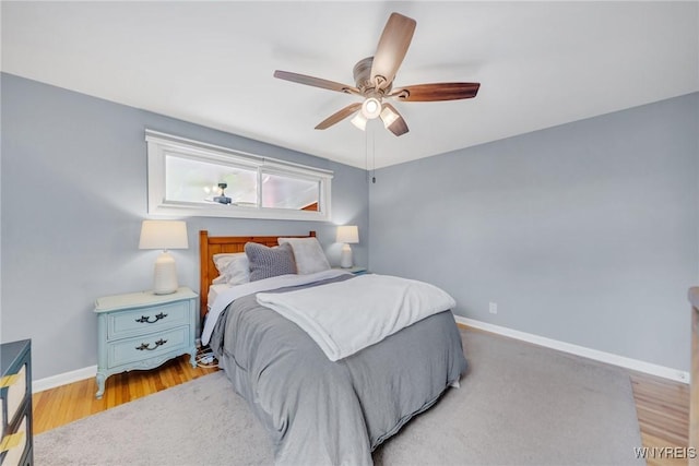 bedroom featuring baseboards, ceiling fan, and light wood-style flooring