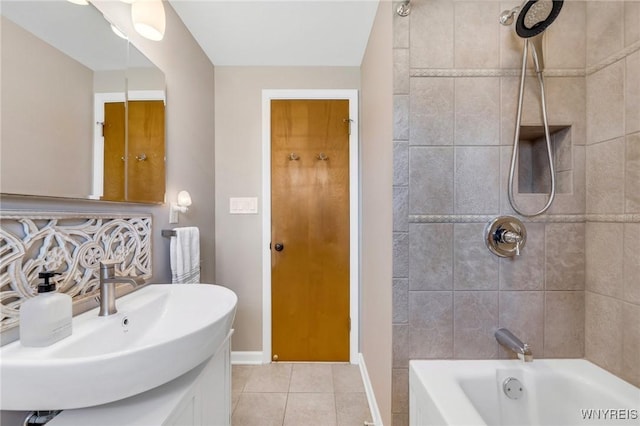 full bath with baseboards, washtub / shower combination, a sink, and tile patterned flooring