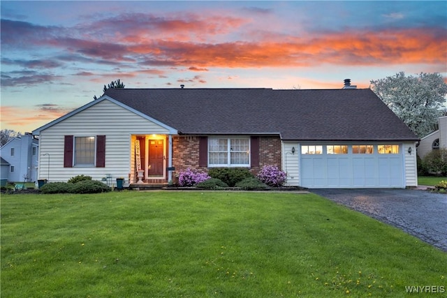 view of front of home with a lawn, aphalt driveway, a shingled roof, and a garage