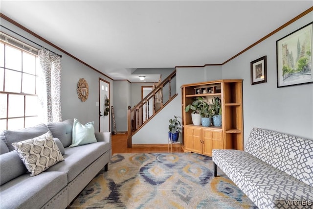 living room featuring crown molding, baseboards, stairs, and wood finished floors