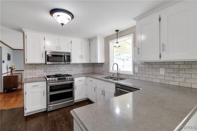 kitchen with white cabinetry, appliances with stainless steel finishes, dark wood-style floors, and a sink