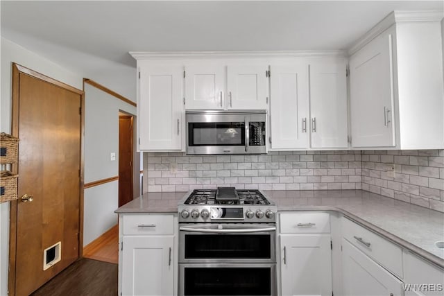 kitchen with backsplash, white cabinetry, appliances with stainless steel finishes, and visible vents