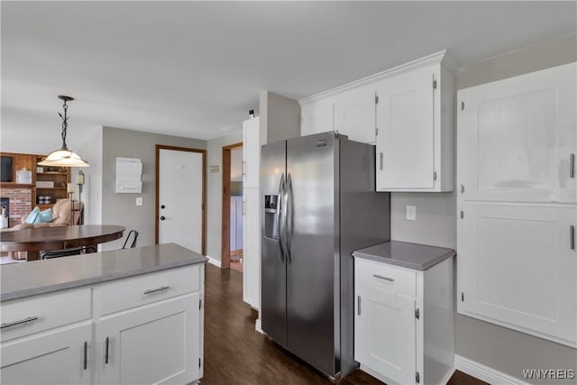 kitchen featuring decorative light fixtures, baseboards, white cabinets, dark wood-style floors, and stainless steel fridge
