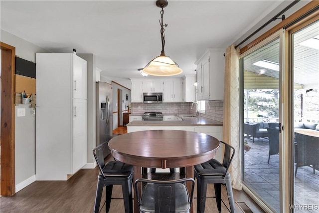 dining space featuring baseboards and dark wood-style floors