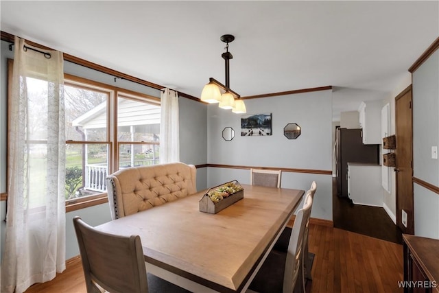 dining space featuring dark wood-style flooring and baseboards