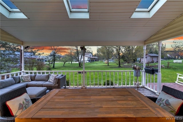 deck featuring a lawn, an outbuilding, and an outdoor living space