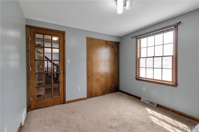 spare room featuring carpet flooring, baseboards, and visible vents