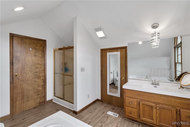 bathroom with visible vents, a stall shower, wood finished floors, and lofted ceiling