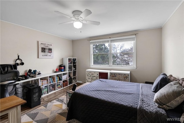 bedroom featuring ceiling fan, ornamental molding, and wood finished floors