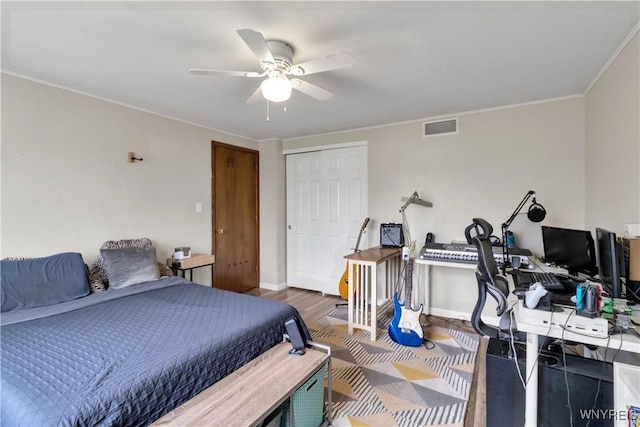 bedroom featuring ceiling fan, visible vents, baseboards, a closet, and ornamental molding