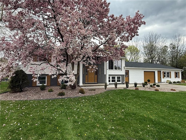 view of front of house featuring driveway, a front yard, and a garage