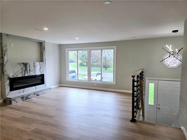 unfurnished living room featuring recessed lighting, baseboards, wood finished floors, and a fireplace