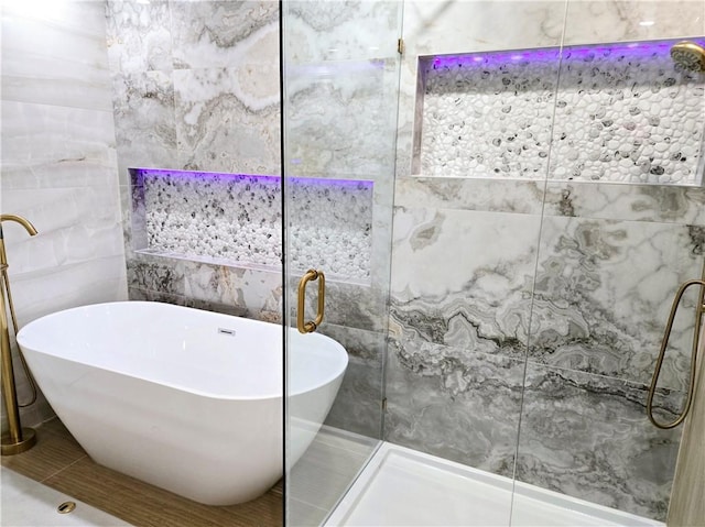 full bath featuring an enclosed shower, tile walls, a soaking tub, and tile patterned floors