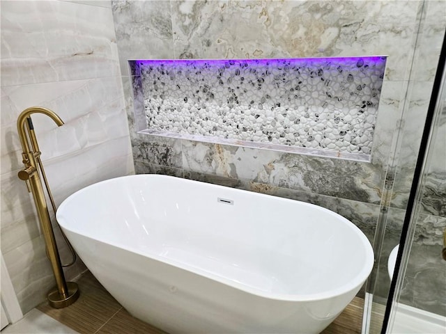 bathroom with a freestanding bath and tile walls