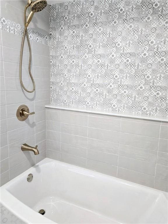 bathroom with wallpapered walls and  shower combination