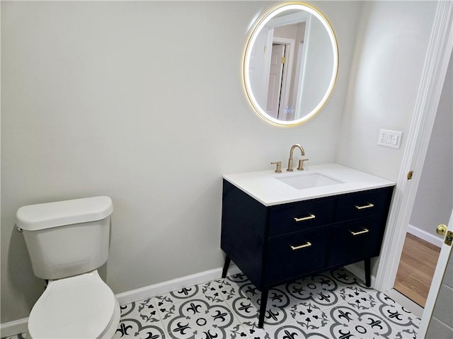 bathroom with baseboards, tile patterned flooring, vanity, and toilet