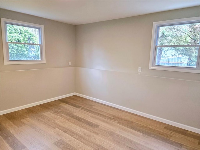 unfurnished room featuring baseboards and light wood-style flooring