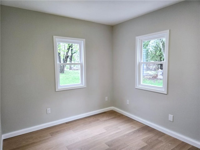 unfurnished room featuring baseboards and wood finished floors