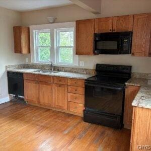 118 Ruhamah Ave, Onondaga, NY 13205 - kitchen with a sink, brown cabinetry, black appliances, and light wood finished floors