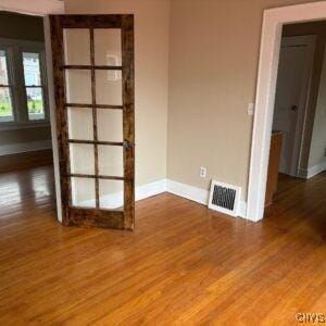 118 Ruhamah Ave, Onondaga, NY 13205 - unfurnished room with baseboards, visible vents, and wood finished floors