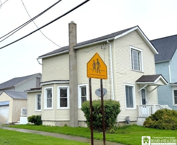 184 W 2nd St, Dunkirk-City, NY 14048 - view of front of property featuring an outdoor structure, a chimney, and a front lawn