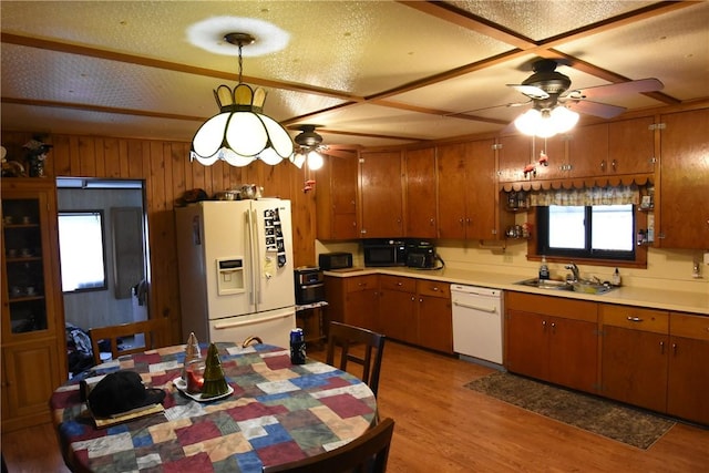 kitchen featuring brown cabinetry, white appliances, ceiling fan, a sink, and light wood-style flooring