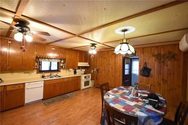 kitchen with brown cabinetry, ceiling fan, under cabinet range hood, and white appliances
