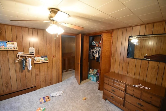 bedroom featuring wooden walls, carpet floors, and a baseboard radiator