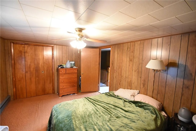 carpeted bedroom featuring wood walls and ceiling fan