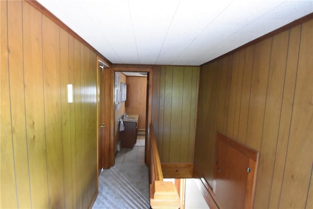 corridor with wooden walls and an upstairs landing