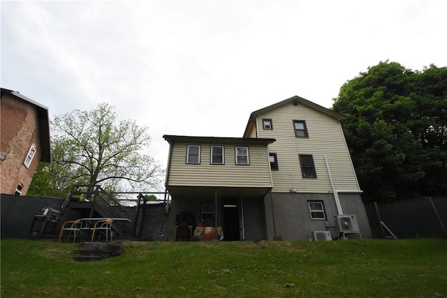 back of house with fence and a yard