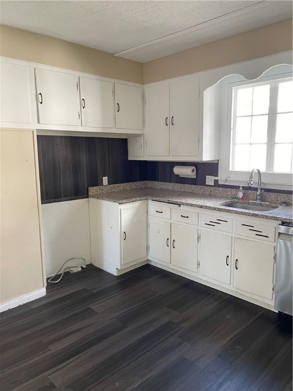 kitchen with a sink, dark wood finished floors, and white cabinetry