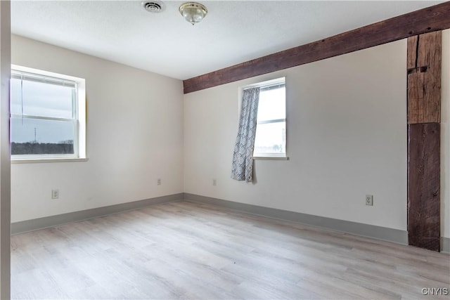 unfurnished room with light wood-style floors, baseboards, and visible vents
