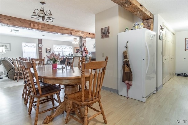 dining room with light wood-style flooring and a notable chandelier