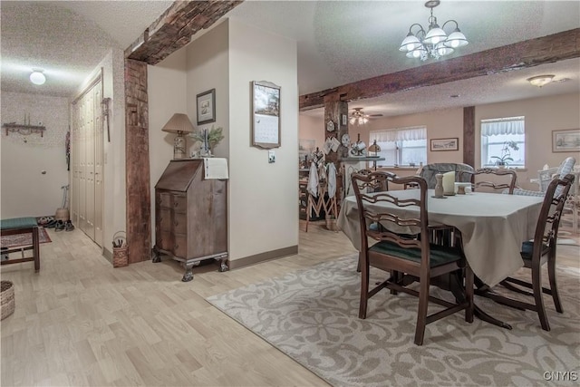 dining area featuring a textured ceiling, light wood-type flooring, baseboards, beamed ceiling, and ceiling fan with notable chandelier