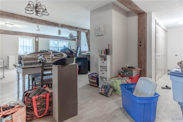 interior space featuring a textured ceiling, beam ceiling, and wood finished floors