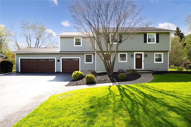 colonial house featuring driveway, a front lawn, and a garage