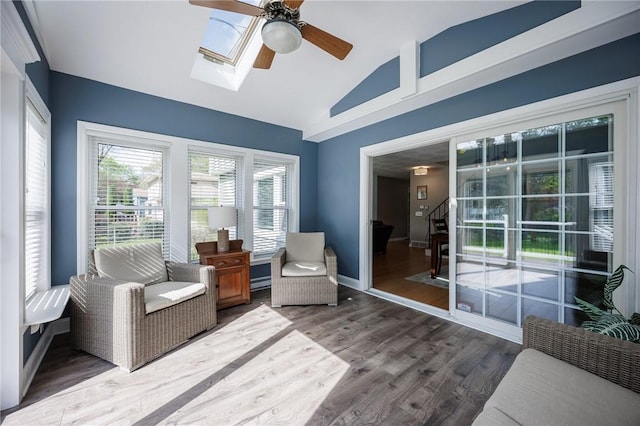 interior space with high vaulted ceiling, stairs, a ceiling fan, wood finished floors, and a skylight