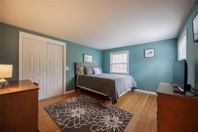 bedroom featuring a closet, baseboards, and wood finished floors