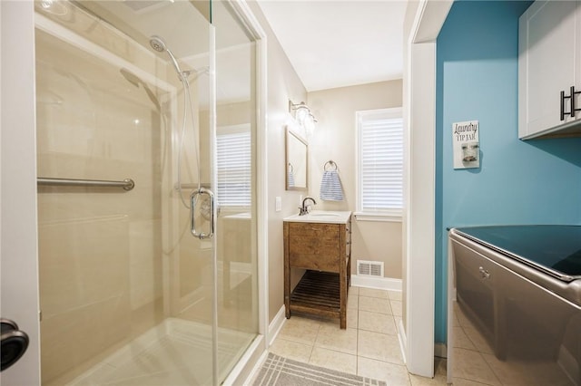 bathroom with visible vents, vanity, tile patterned flooring, baseboards, and a shower stall